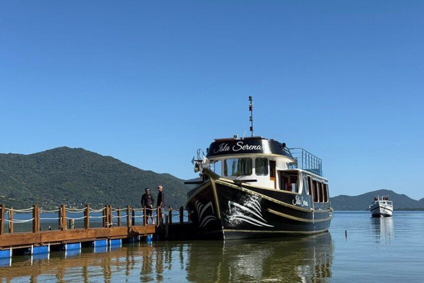 A boat named 'La Serena' docked at a pier with a mountainous backdrop. 5