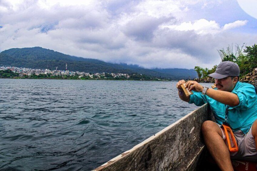 A person in a canoe on a body of water with a mountainous landscape in the background. 5
