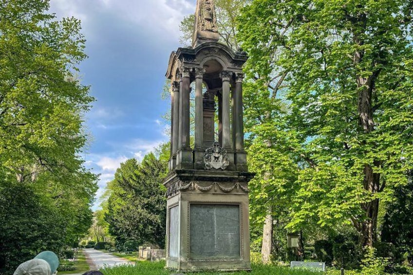A classical monument with columns, surrounded by lush greenery and trees. 2
