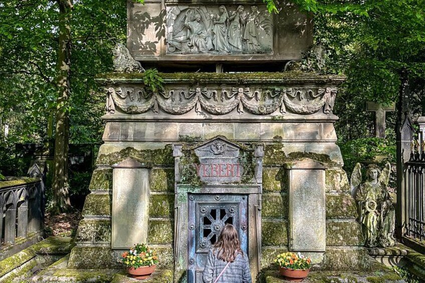 A stone monument with a door, surrounded by greenery. 1