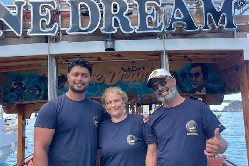 Three people in front of a sign that reads 'NEDREAM' with a logo and a palm tree graphic. 4