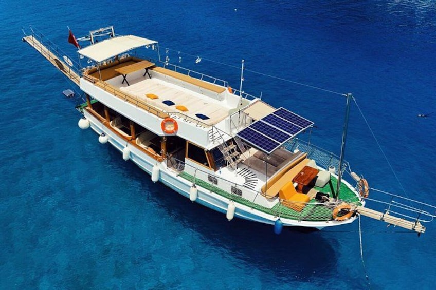 A large boat with multiple decks, solar panels, and lifebuoys. 1