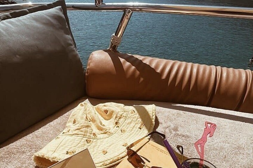 A boat's interior with a cushion, a folded garment, and a pair of sunglasses. 2