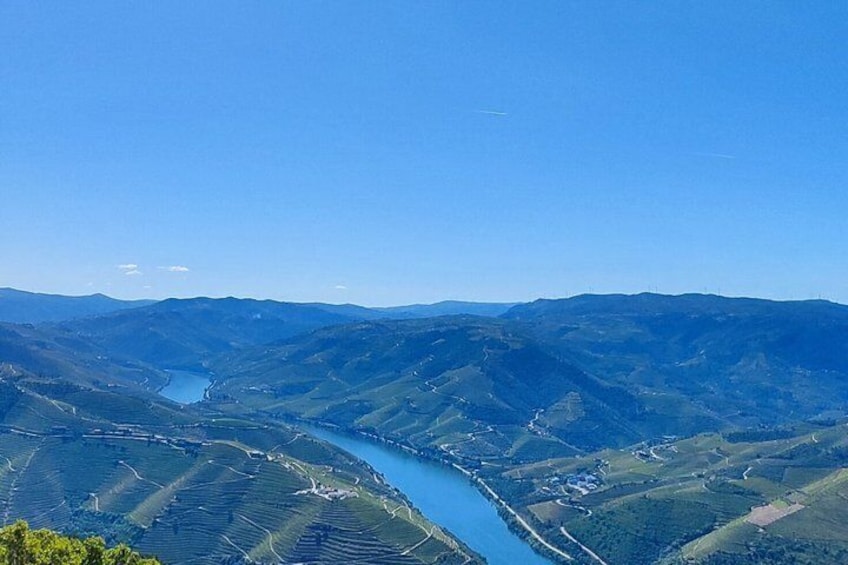 A river winding through a valley with terraced fields and distant mountains. 1