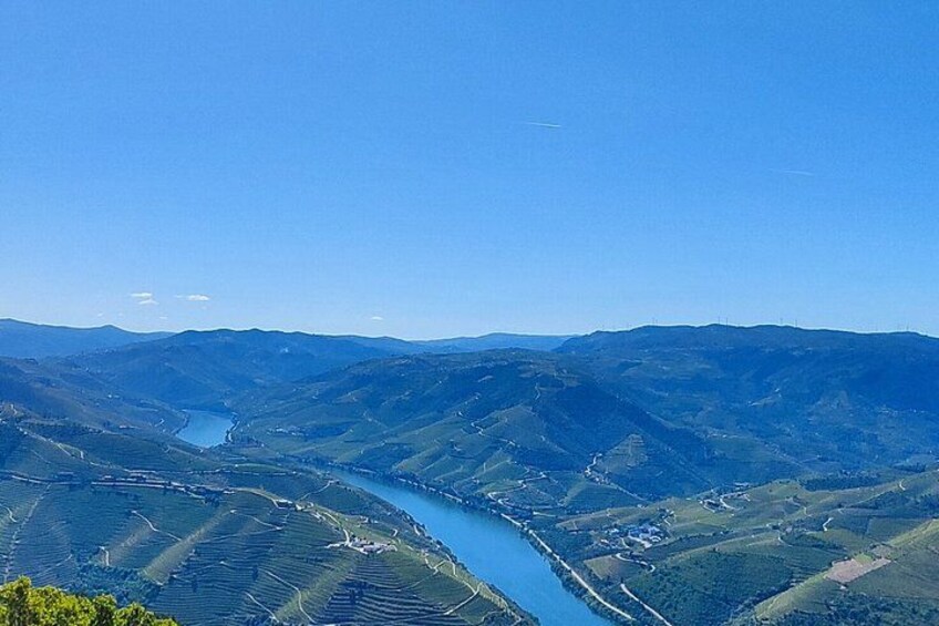 A river winding through a valley with terraced fields and distant hills. 4