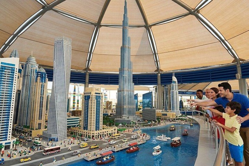 A detailed scale model of a city with skyscrapers, a waterfront, and miniature vehicles. 2