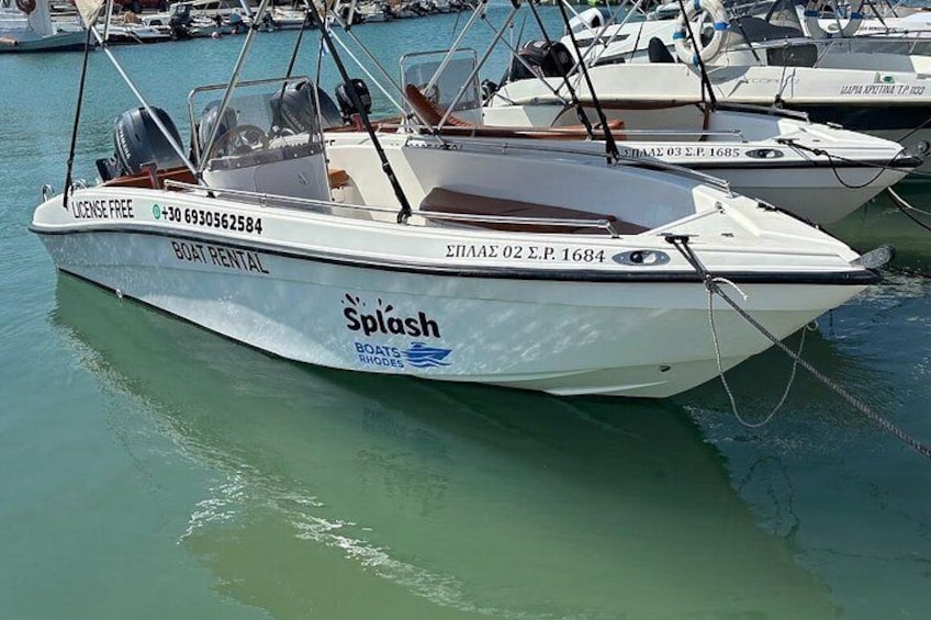 A white boat with 'Boat Rental' and 'Splash' branding, docked at a marina with other boats. 4