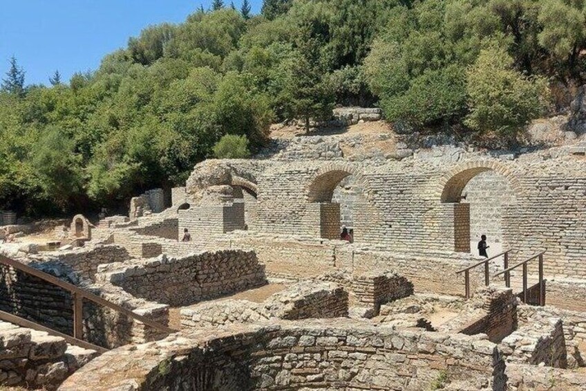 Ancient ruins with stone walls and arches, surrounded by trees. 4