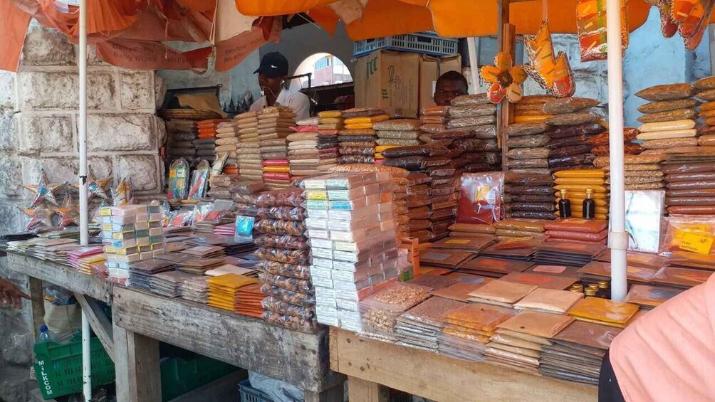 A market stall with stacks of packaged goods and a variety of items on display. 1