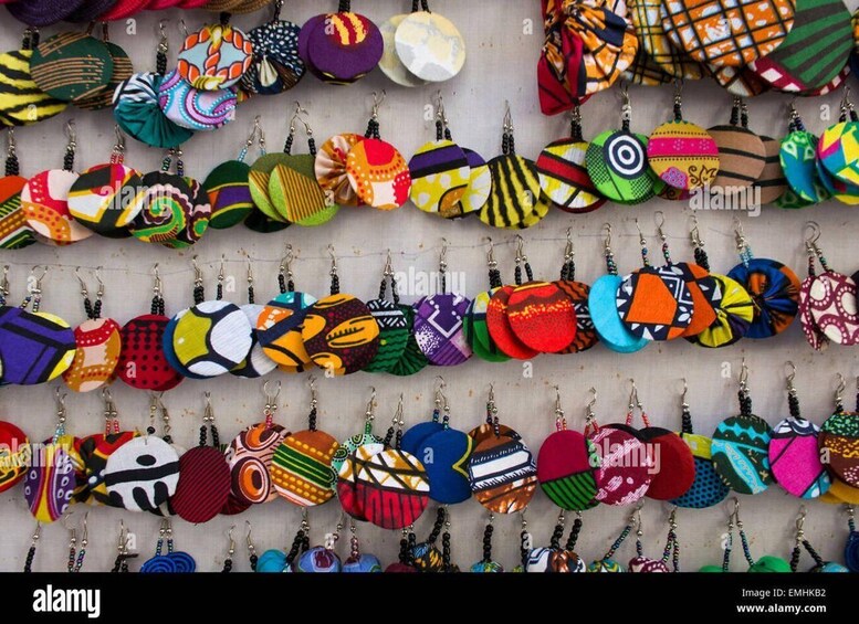 A collection of colorful fabric keychains displayed on hooks. 3