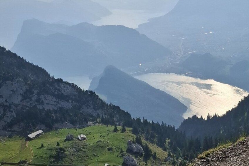 A mountainous landscape with a lake, a small building, and a road. 4