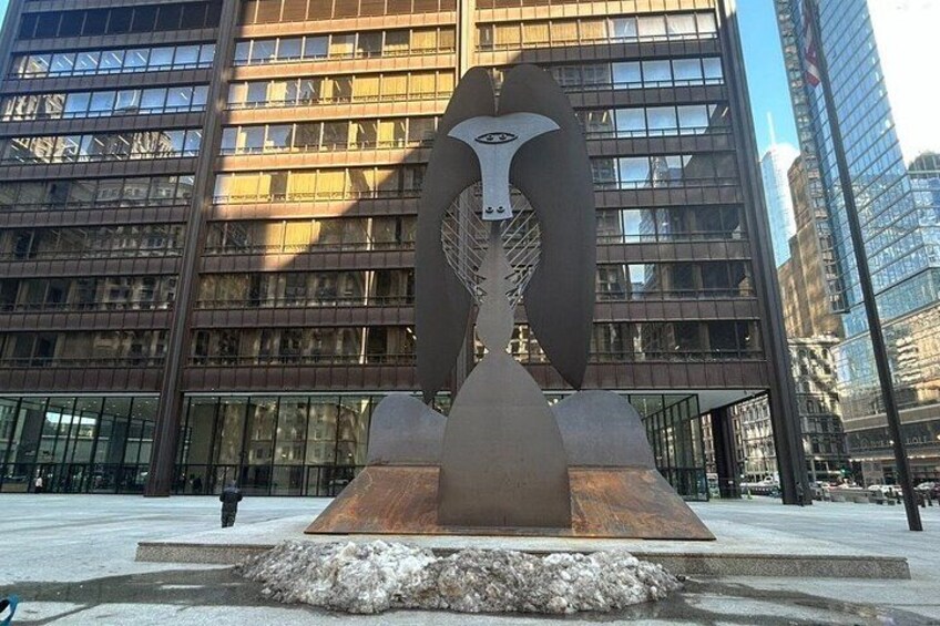 A modern sculpture in an urban plaza with a building in the background. 3