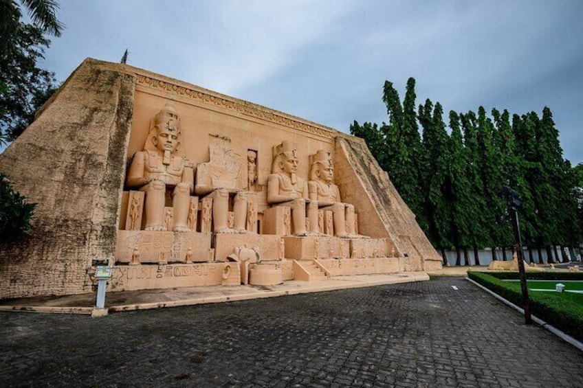 A large stone structure with seated figures and a pyramid base. 5