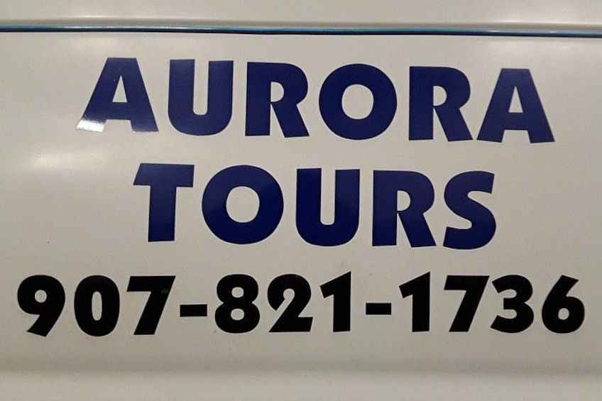 A sign with the text 'AURORA TOURS' and a phone number '907-821-1736'. 4