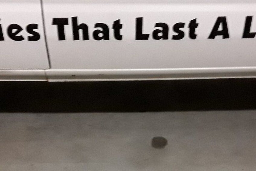 A white sign with black lettering, partially obscured by a shadow. 3