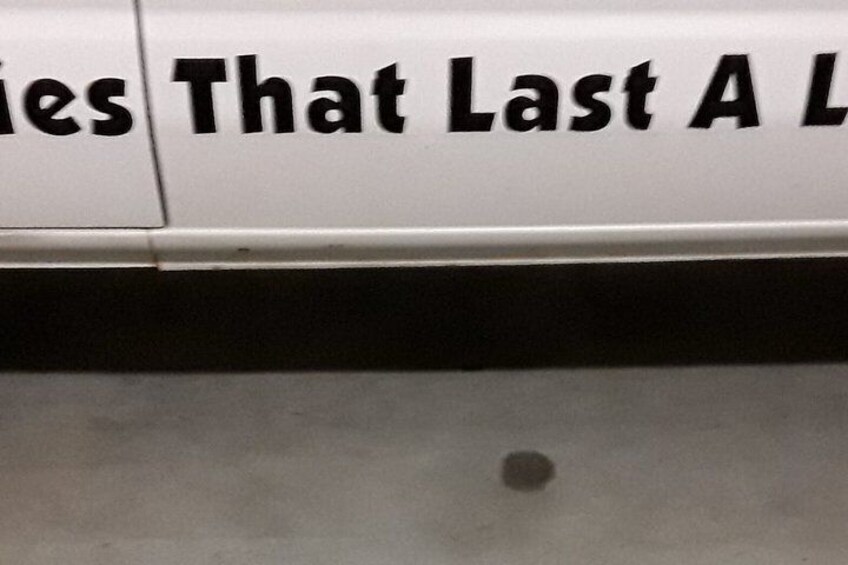 A white sign with black lettering, partially obscured by a shadow. 5