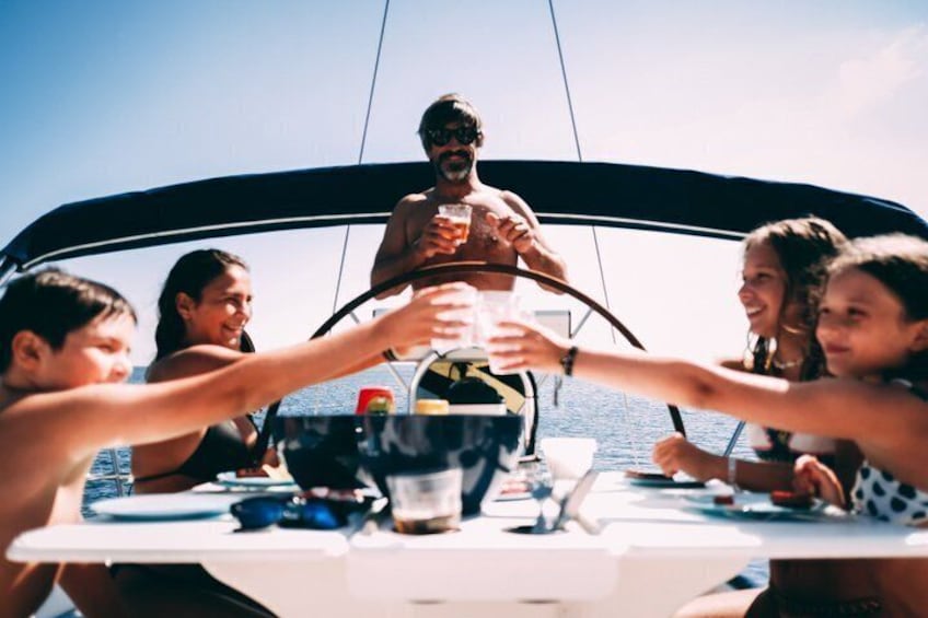 A group of people on a boat, toasting with drinks. 2