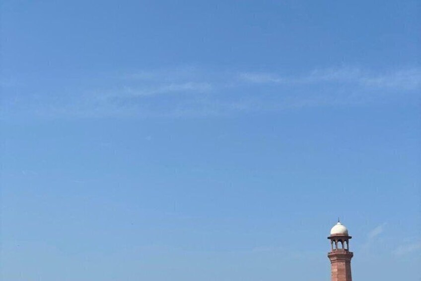 A clear blue sky with a prominent red tower featuring a dome. 5