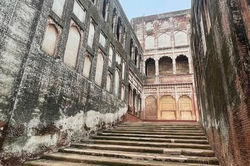 A staircase leading up to a building with arched windows and a balcony. 3