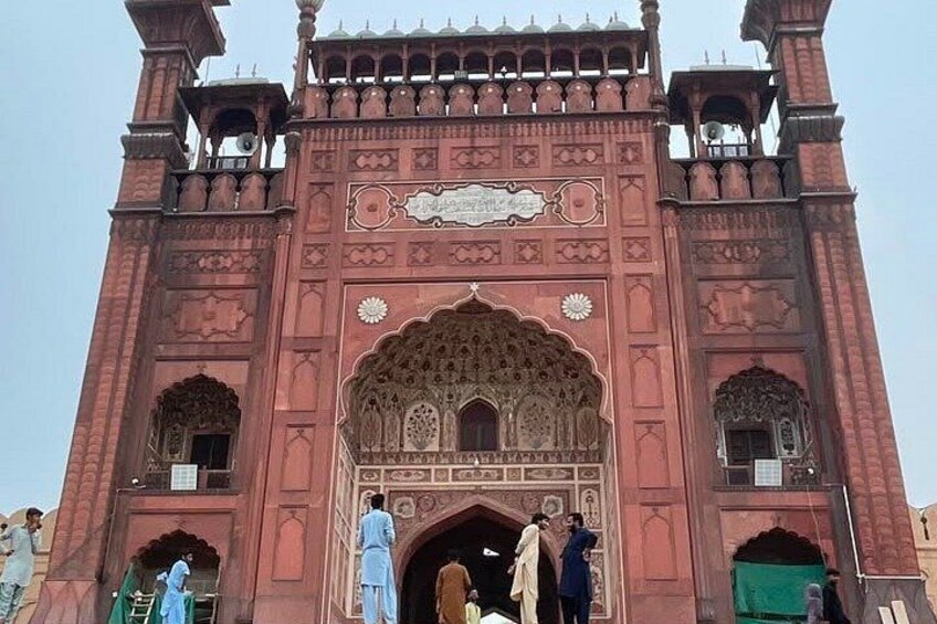 A large, ornate red gate with intricate carvings and a central archway. 2