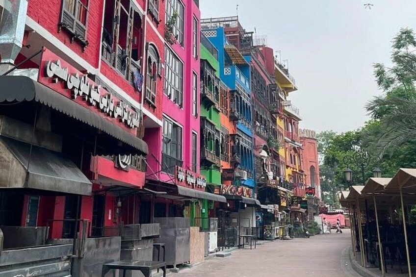 A street lined with colorful buildings, some with signs in a foreign language, and a few shops with awnings. 4