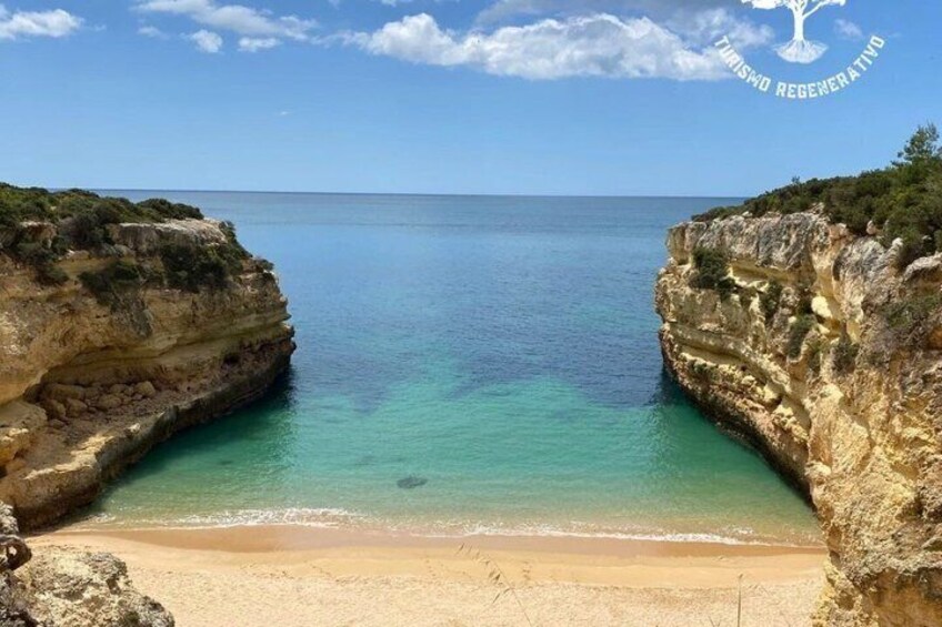 A coastal landscape with cliffs, a beach, and clear turquoise waters. 1