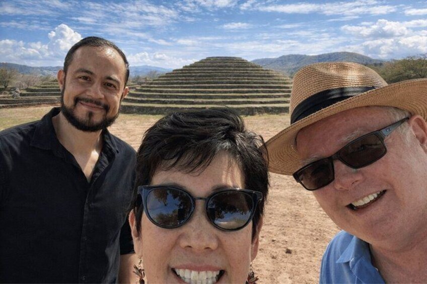 Three people in a dry, hilly landscape with terraced fields. 5