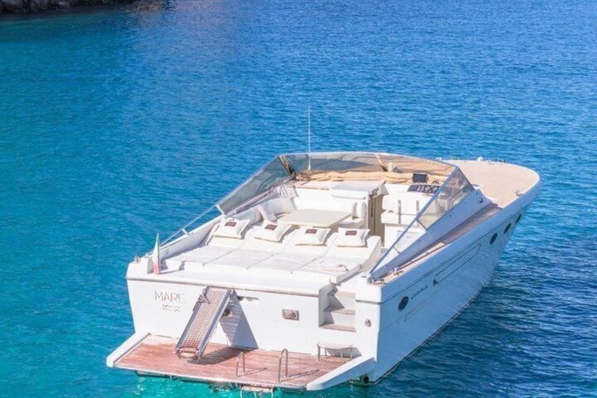 A white yacht named 'MARINA' on clear blue water. 4