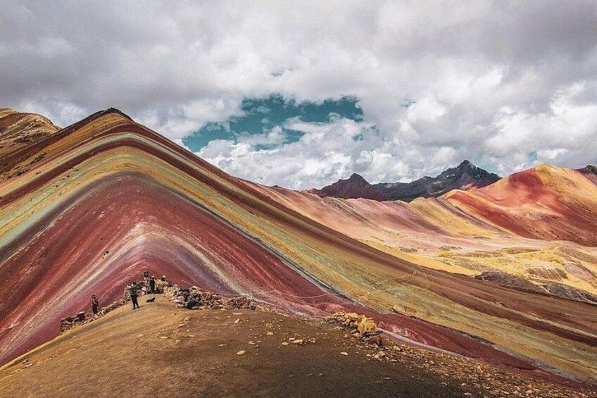 A colorful landscape with layered hills and a group of people at the base. 3