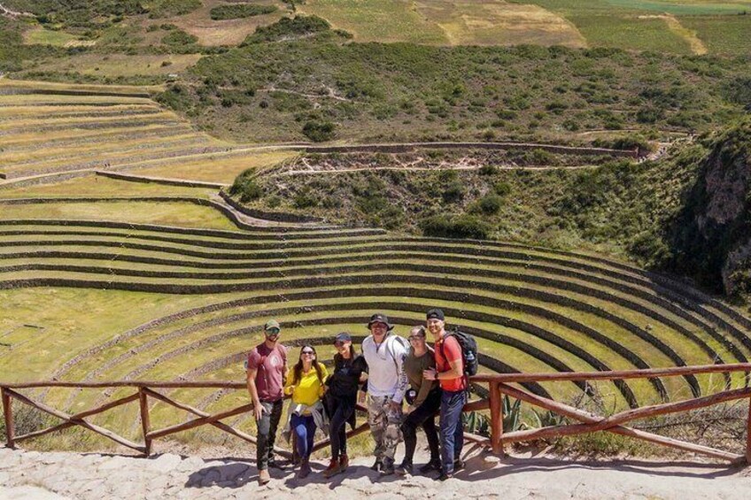 A group of people standing on a viewing platform overlooking terraced agricultural fields. 1