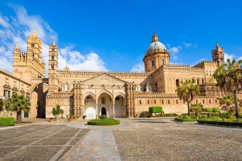 A historic building with a large dome, arched entrance, and two bell towers. 1