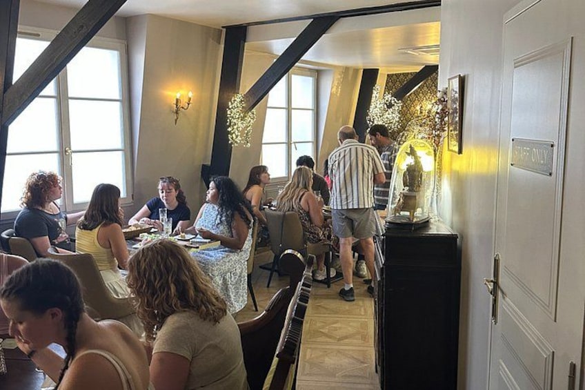 A restaurant interior with tables, chairs, and a few people dining. 3