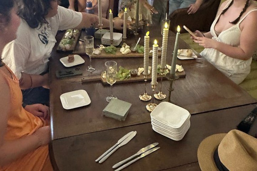 A dining table with candles, plates, cutlery, and a hat. 2
