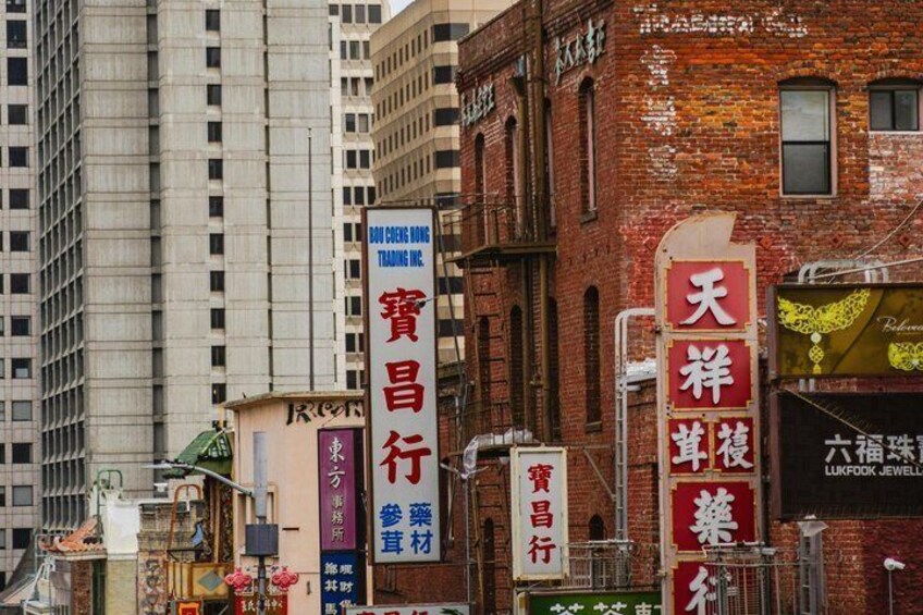 A city street with various commercial signs, including a prominent red sign with Chinese characters. 3