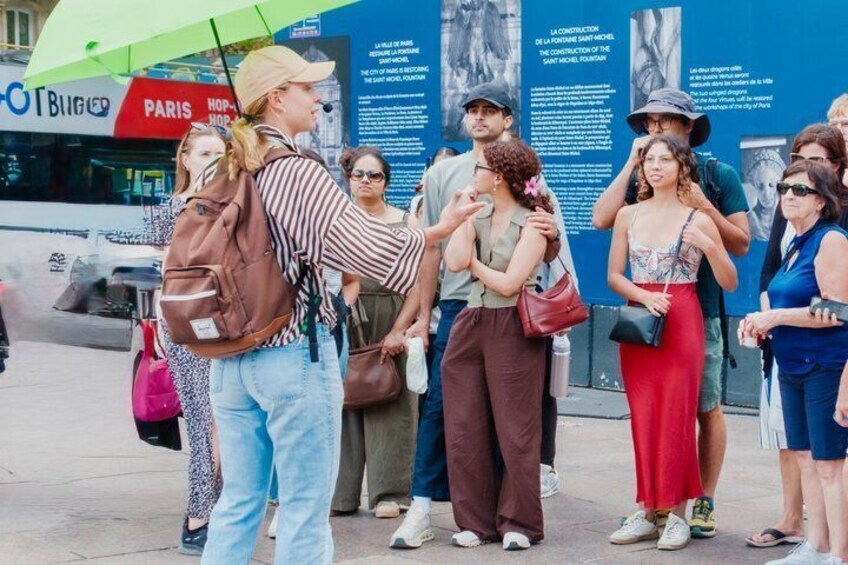 A group of tourists standing in front of a historical building with informational plaques. 2