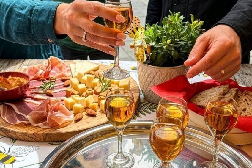 A table with cheese, cured meats, and glasses of wine. 1