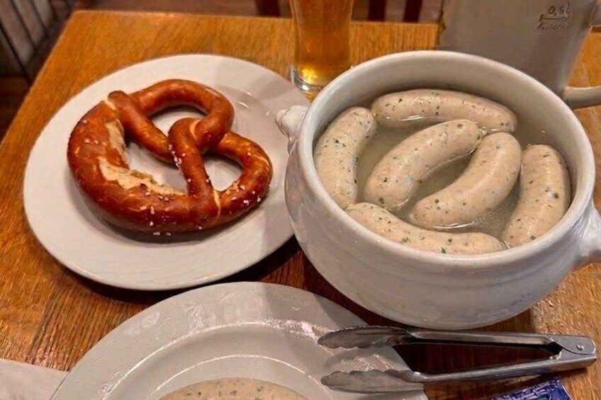 A pretzel and sausages on a table. 2