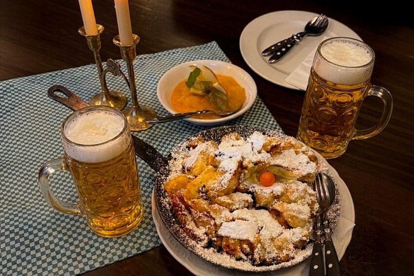 A dessert plate with powdered sugar, a beer mug, a bowl of soup, and a candle holder on a table. 5