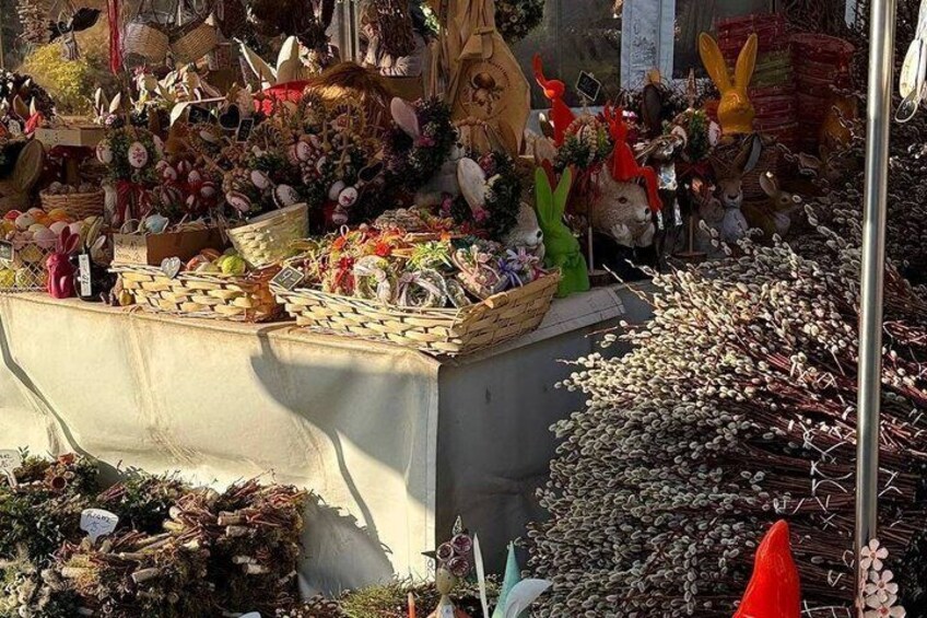 A market stall with various items including baskets, flowers, and figurines. 4