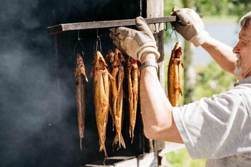A person hanging fish on a rack over a grill. 3