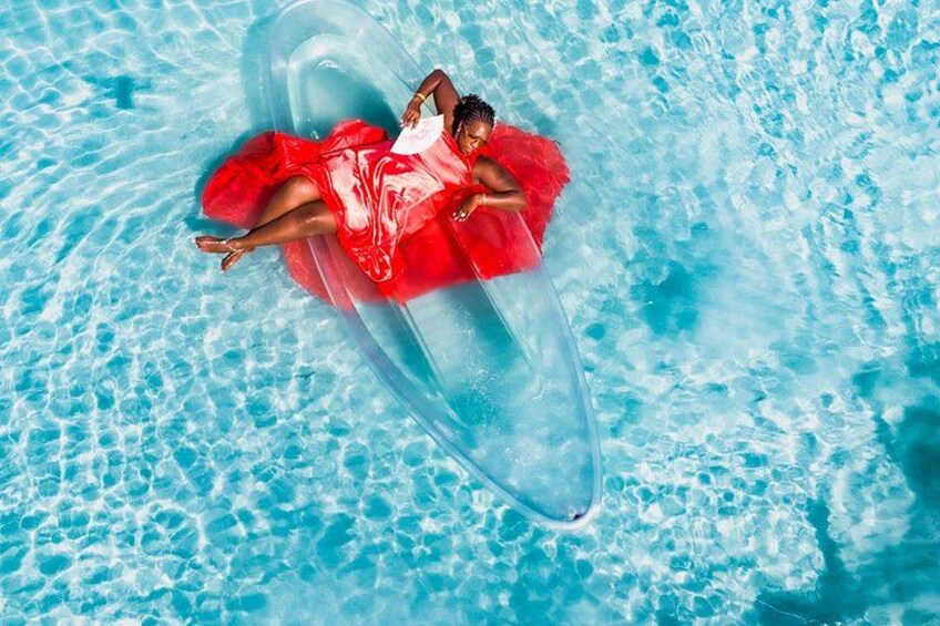 A person floating on a clear inflatable in a swimming pool. 1