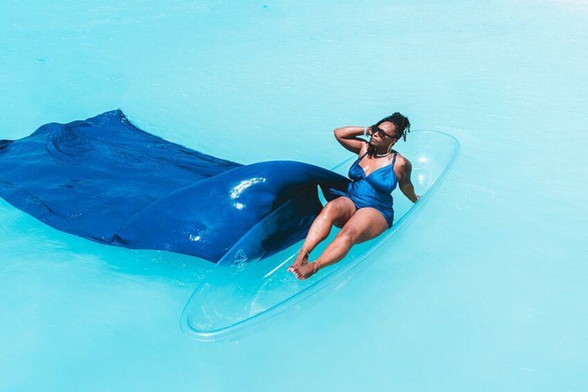 A person lying on a blue inflatable raft in a swimming pool. 5