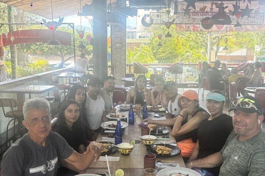 A group of people dining at an outdoor restaurant with tables and chairs. 1