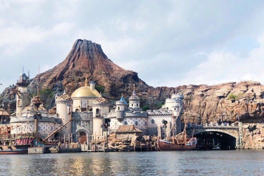 A church with a golden dome, a mountain in the background, and a bridge over water. 3