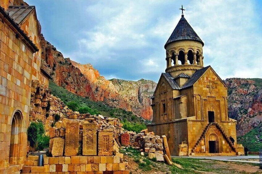 A historic church with a bell tower, surrounded by rugged terrain and ancient ruins. 2