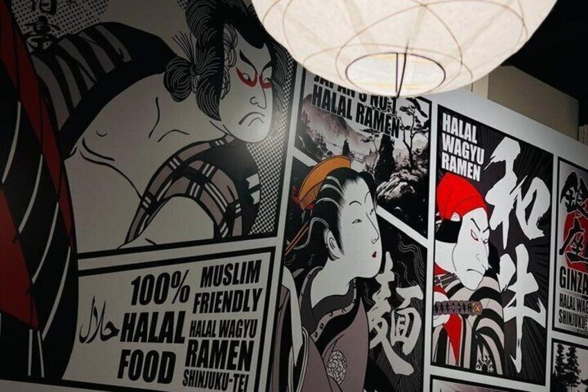 A wall with Japanese artwork and text advertising halal food. 2