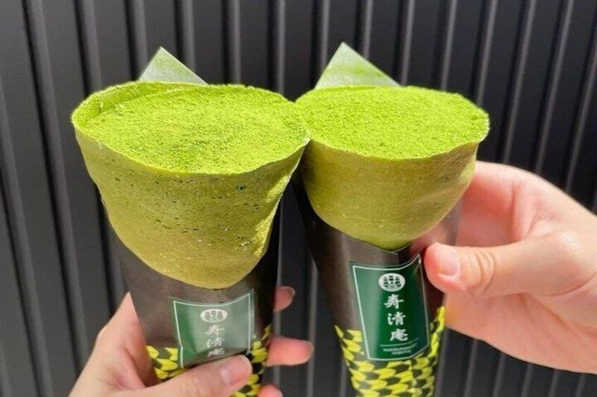 Two green tea cones with labels, held by a person. 3