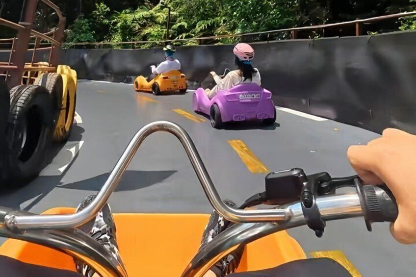A go-kart track with orange go-karts and a purple go-kart in motion. 2
