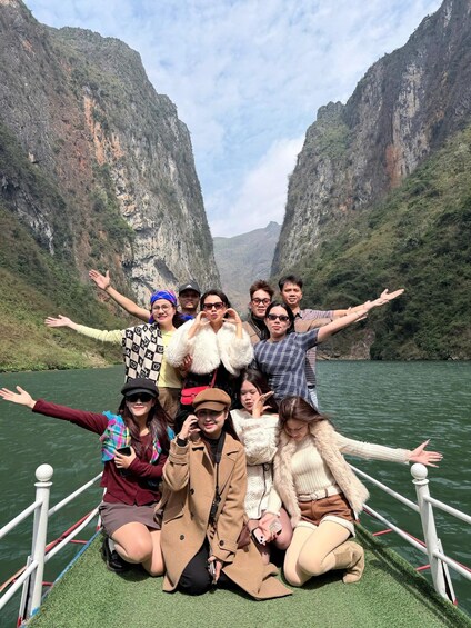 A group of people on a boat with a canyon in the background. 1