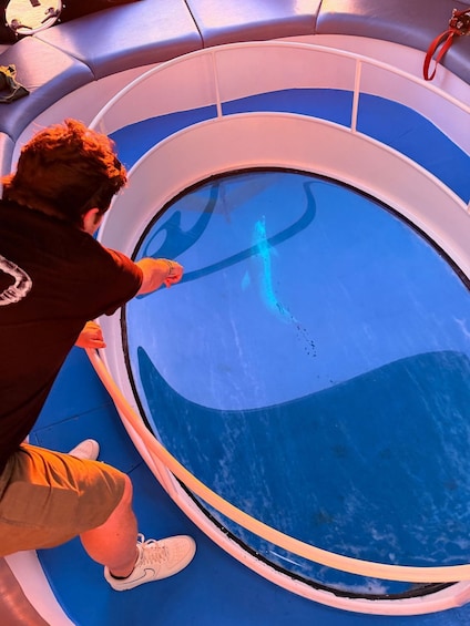 A person cleaning a large, circular pool with a hose. 2